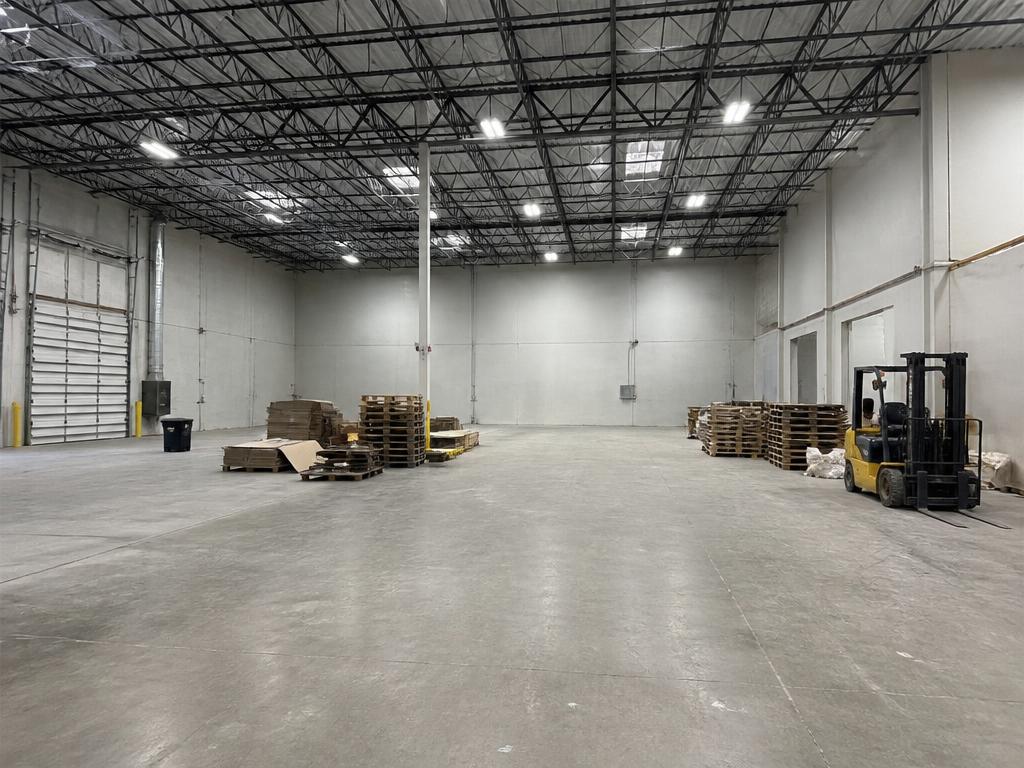Interno di box e magazzino svuotato con pallet residui